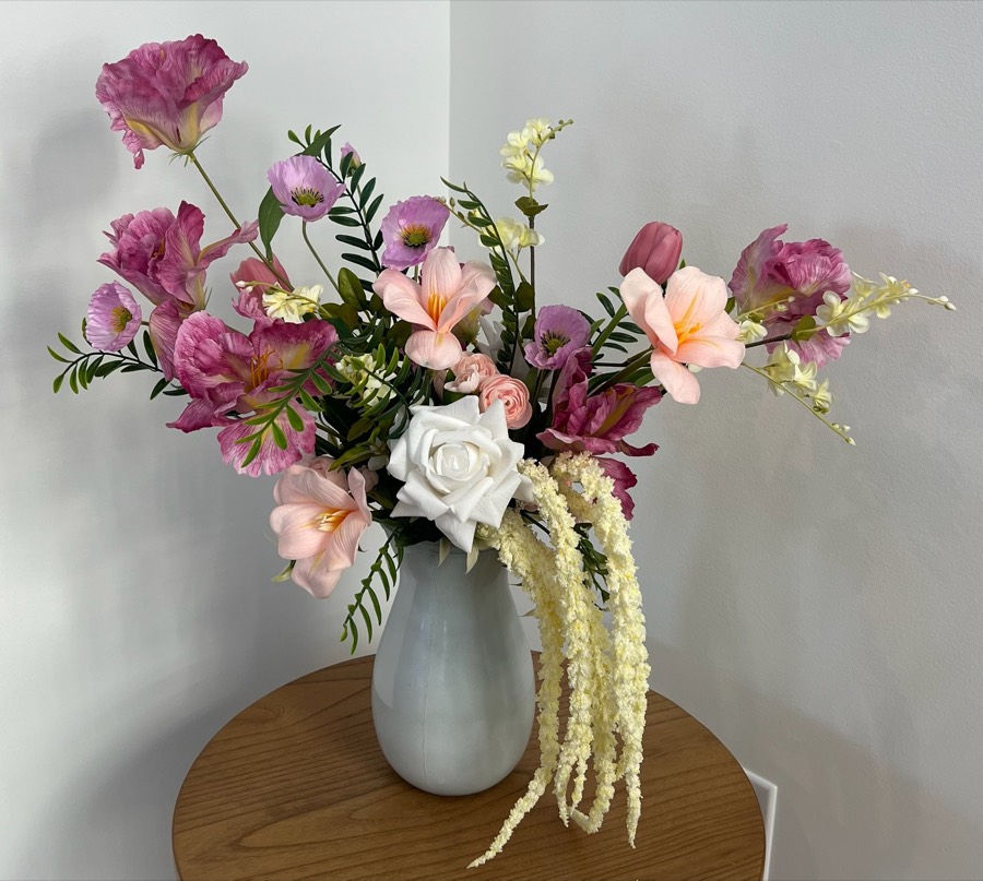 Premium spring arrangement: a fuller arrangement of pink and blush blooms, a white rose and trailing amaranthus in a soft grey vase